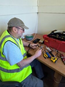 man at bench soldering equipment